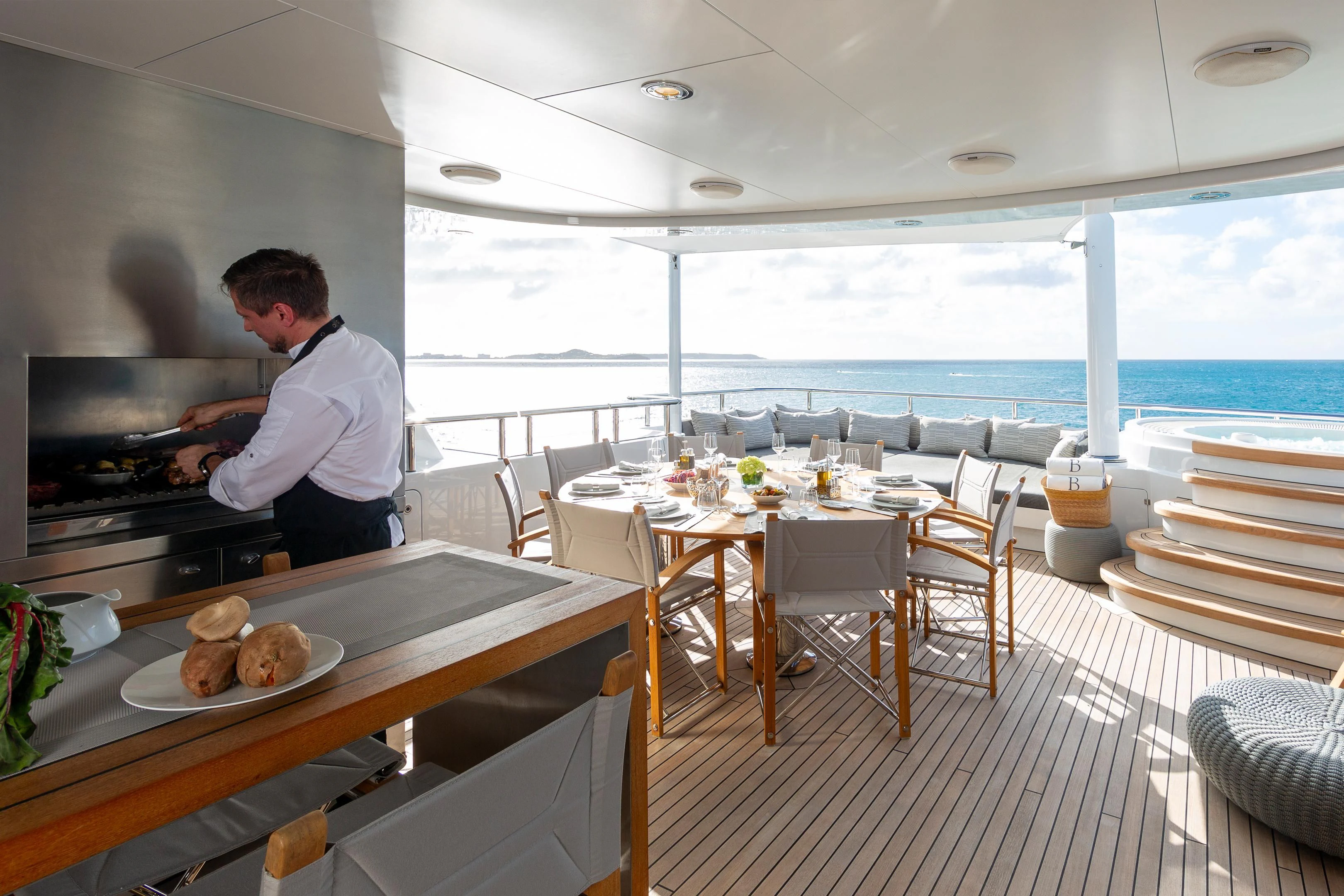 a person sitting at a table with food on it aboard BRAVADO Yacht for Sale