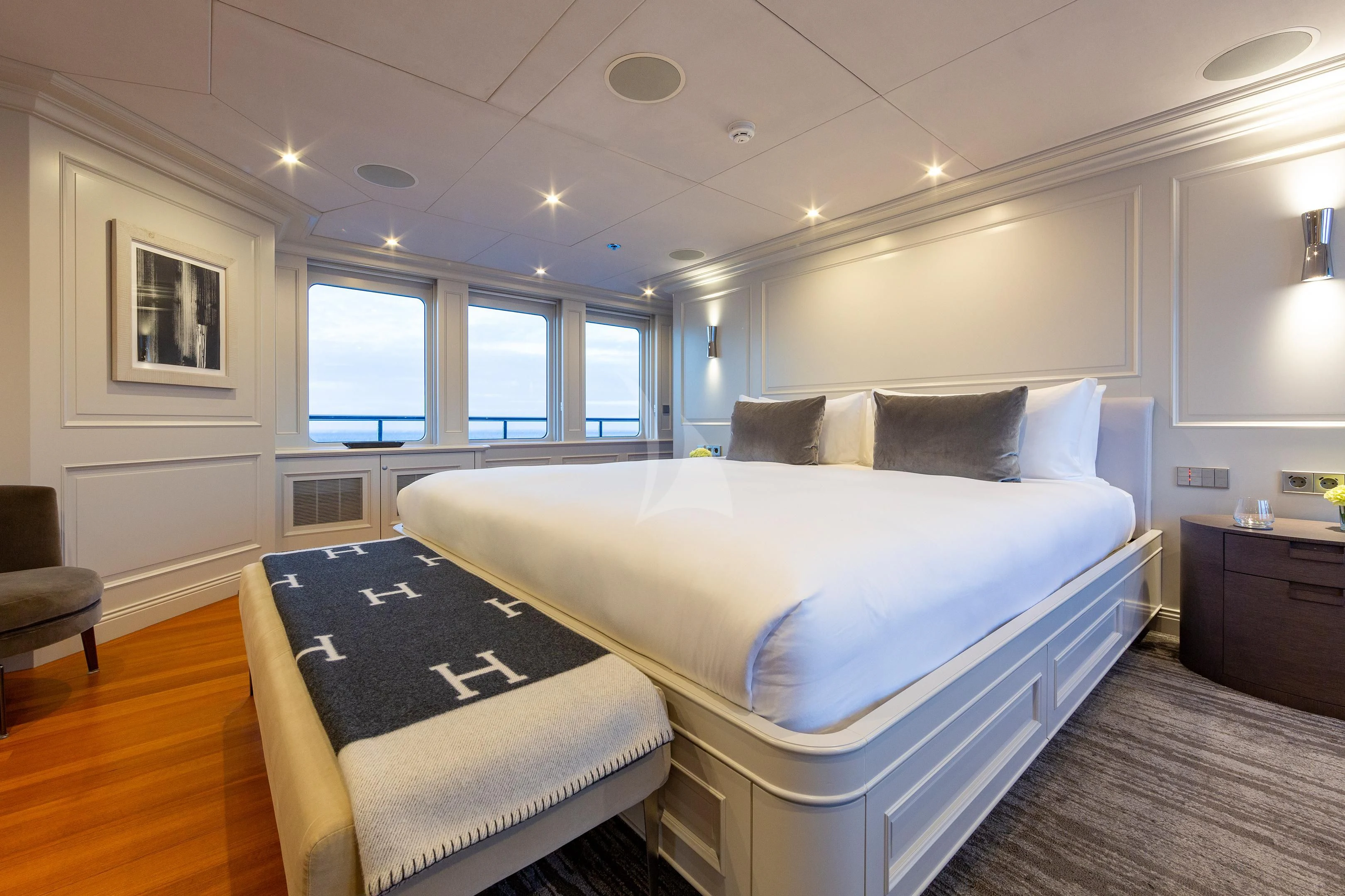a bedroom with a bed and a chair aboard BRAVADO Yacht for Sale