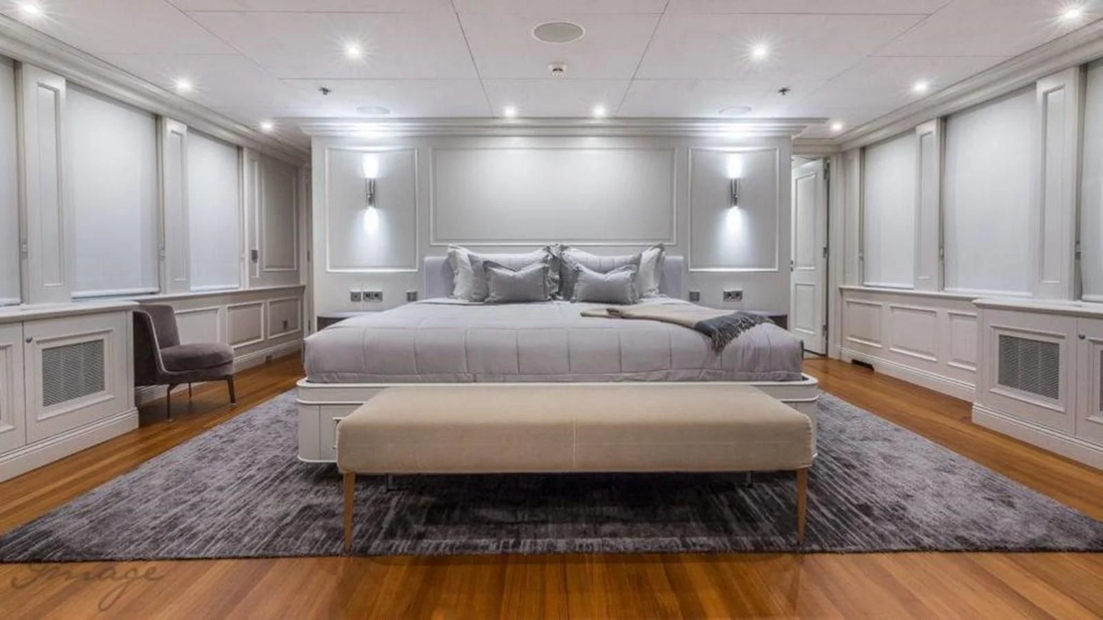 a large bedroom with a bed and a chair aboard BRAVADO Yacht for Sale