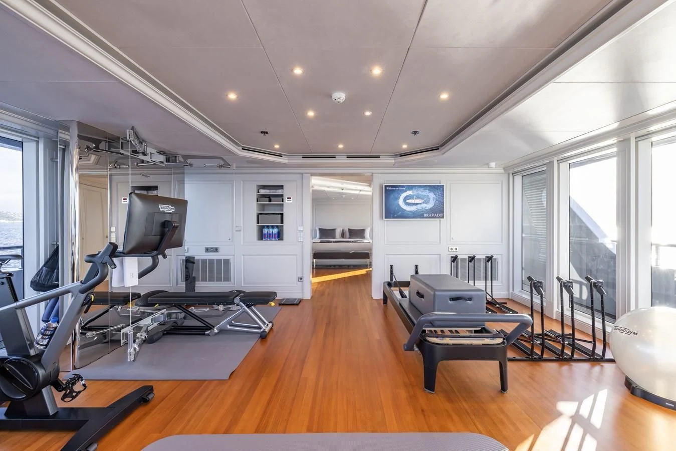 a room with a large mirror and a table with chairs and a television aboard BRAVADO Yacht for Sale