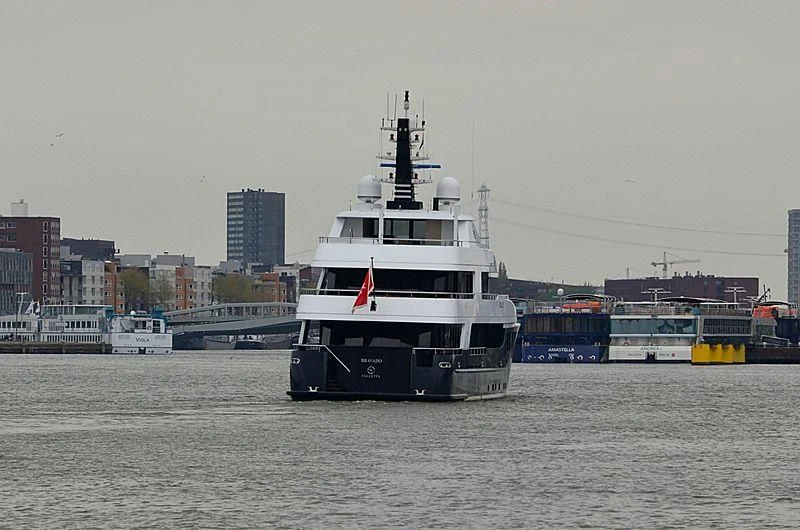 a large white boat in a harbor aboard BRAVADO Yacht for Sale
