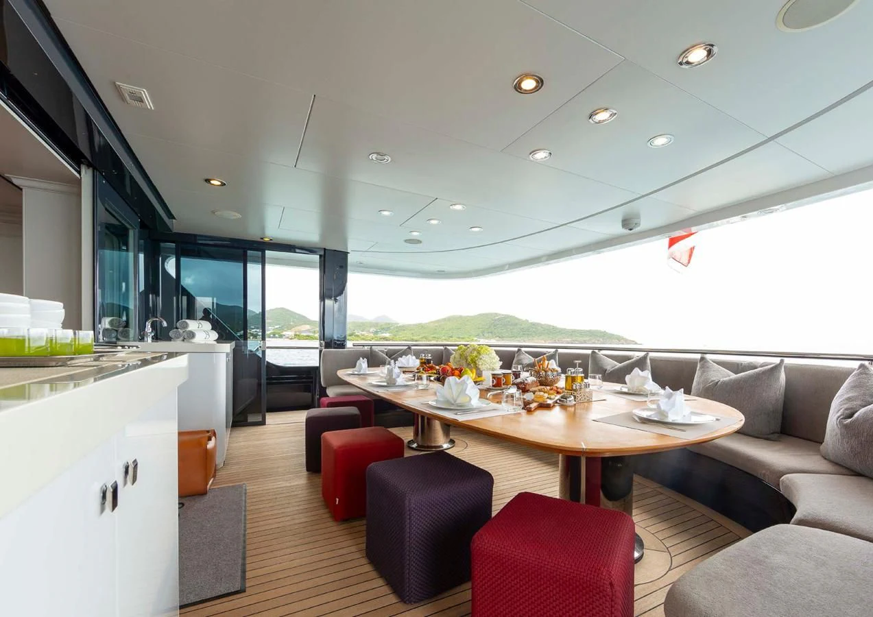 a modern looking kitchen with a large table and chairs aboard BRAVADO Yacht for Sale