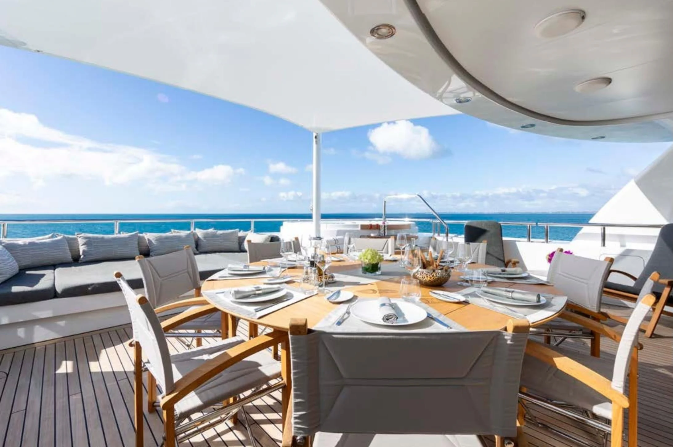 a dining table on a deck overlooking the ocean aboard BRAVADO Yacht for Sale