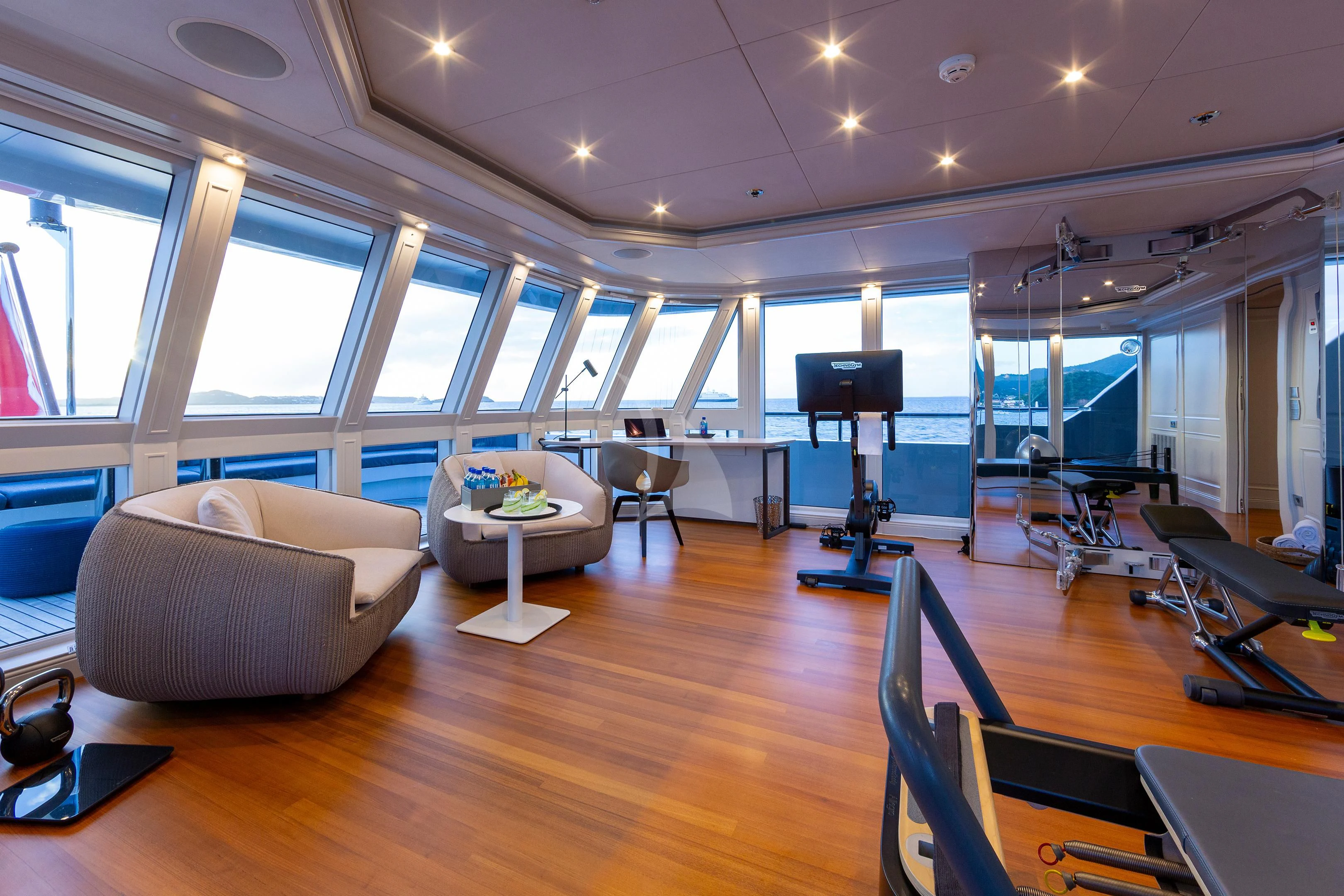 a room with a large window and a table with chairs and a large window aboard BRAVADO Yacht for Sale