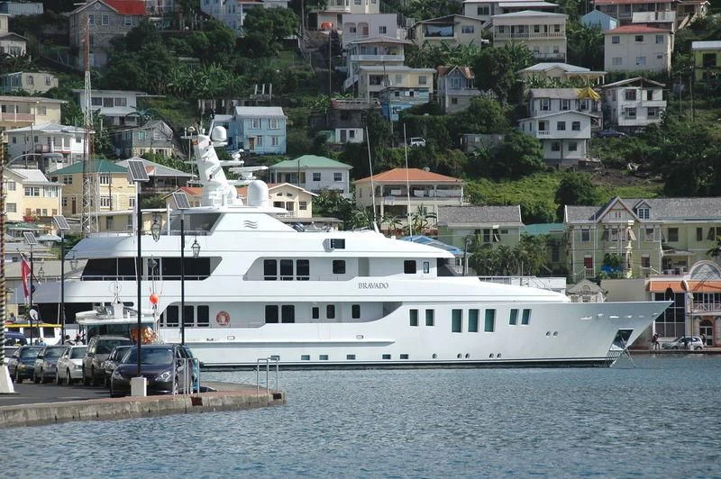 a large white boat in a harbor aboard BRAVADO Yacht for Sale