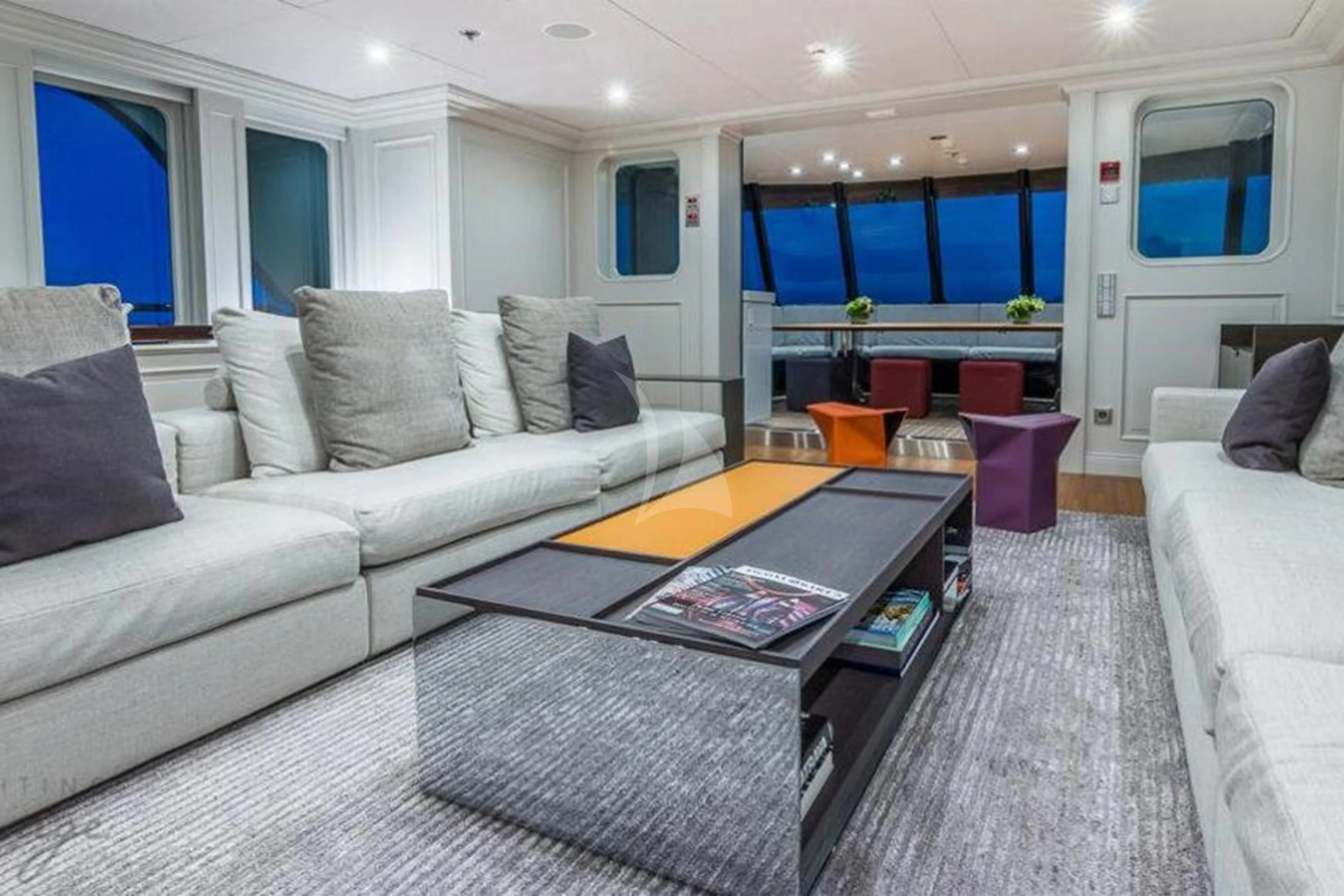 a living room with a large glass coffee table aboard BRAVADO Yacht for Sale