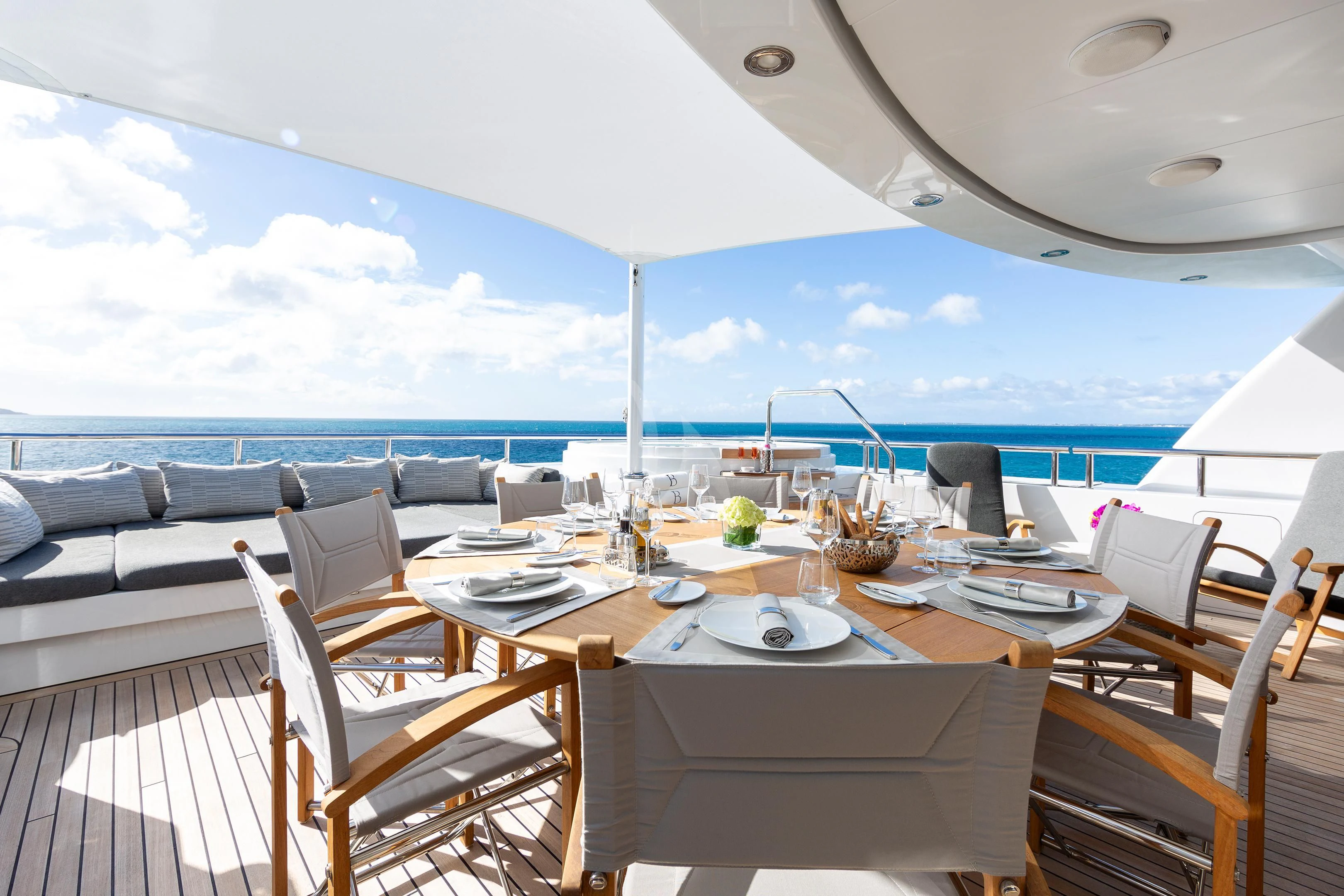 a table set for a meal on a deck overlooking the ocean aboard BRAVADO Yacht for Sale