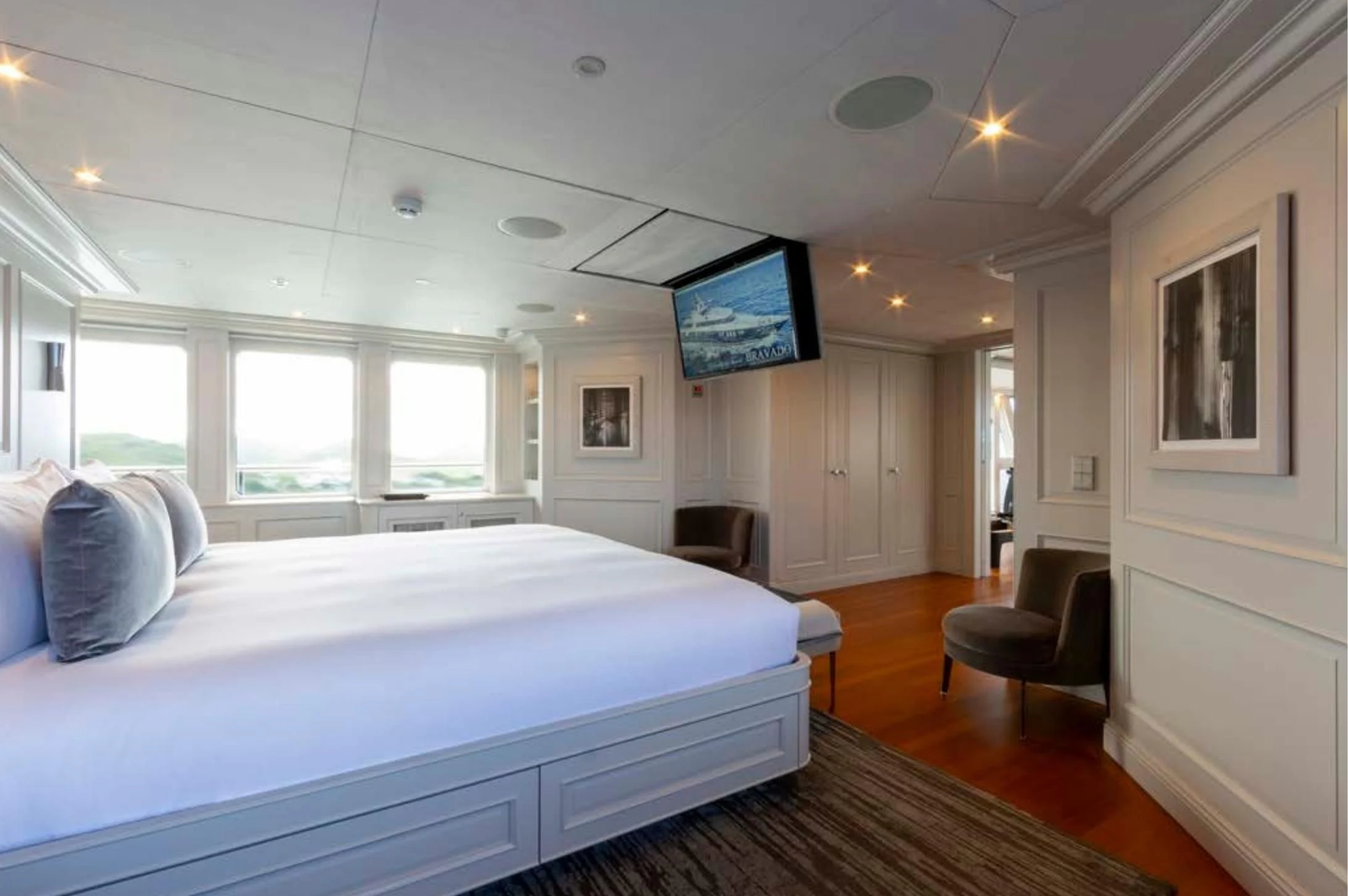 a bedroom with a bed and a chair aboard BRAVADO Yacht for Sale