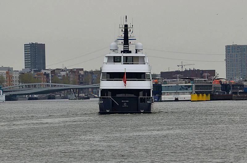 a large white boat in a harbor aboard BRAVADO Yacht for Sale
