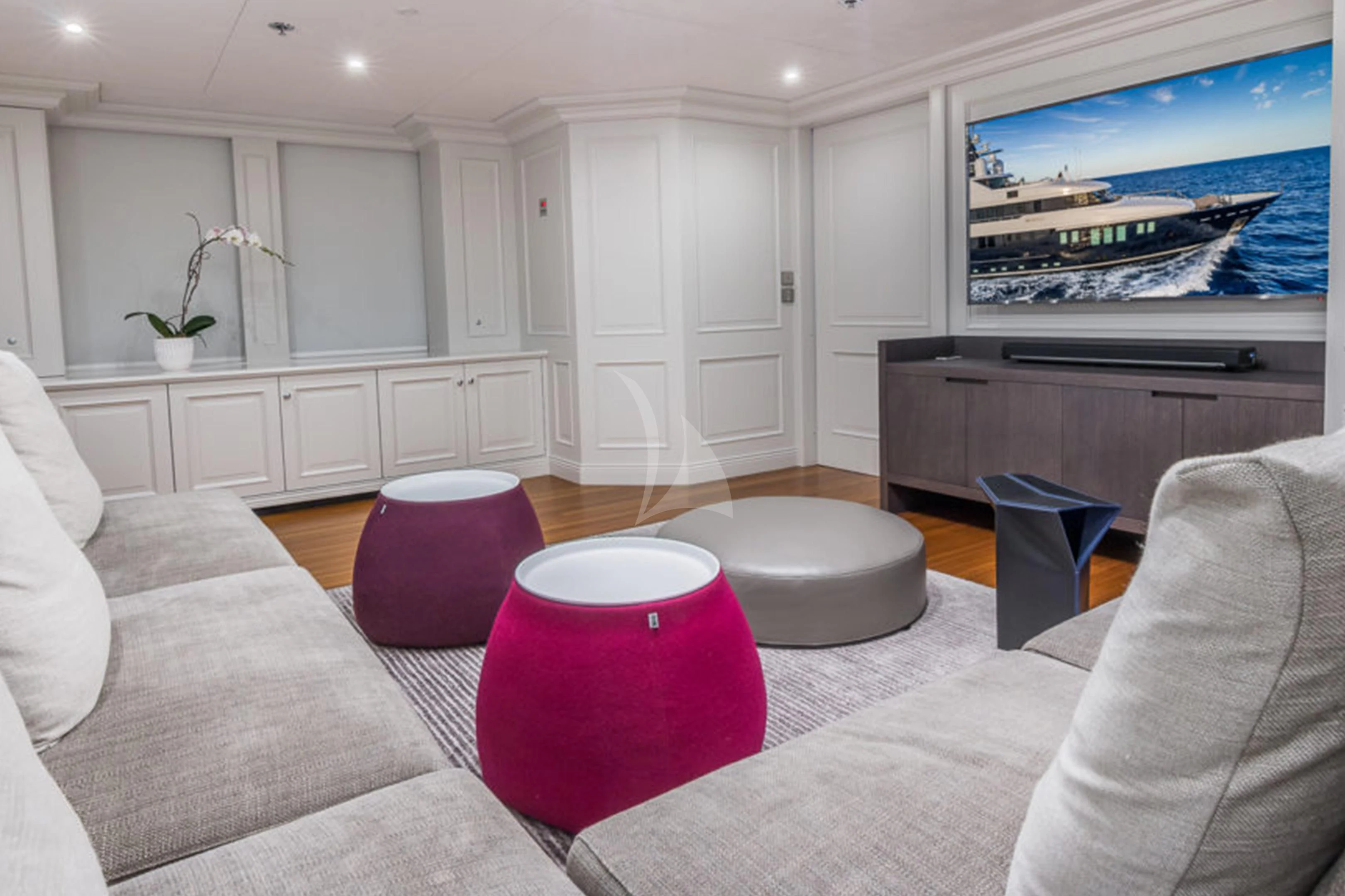 a living room with a tv on the wall aboard BRAVADO Yacht for Sale