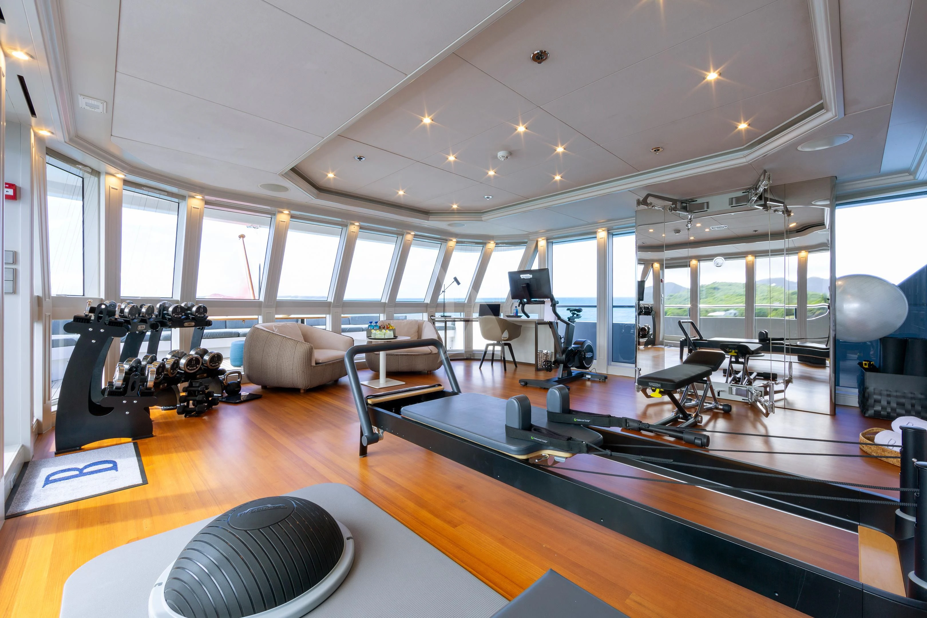 a room with a large mirror and a table with chairs aboard BRAVADO Yacht for Sale