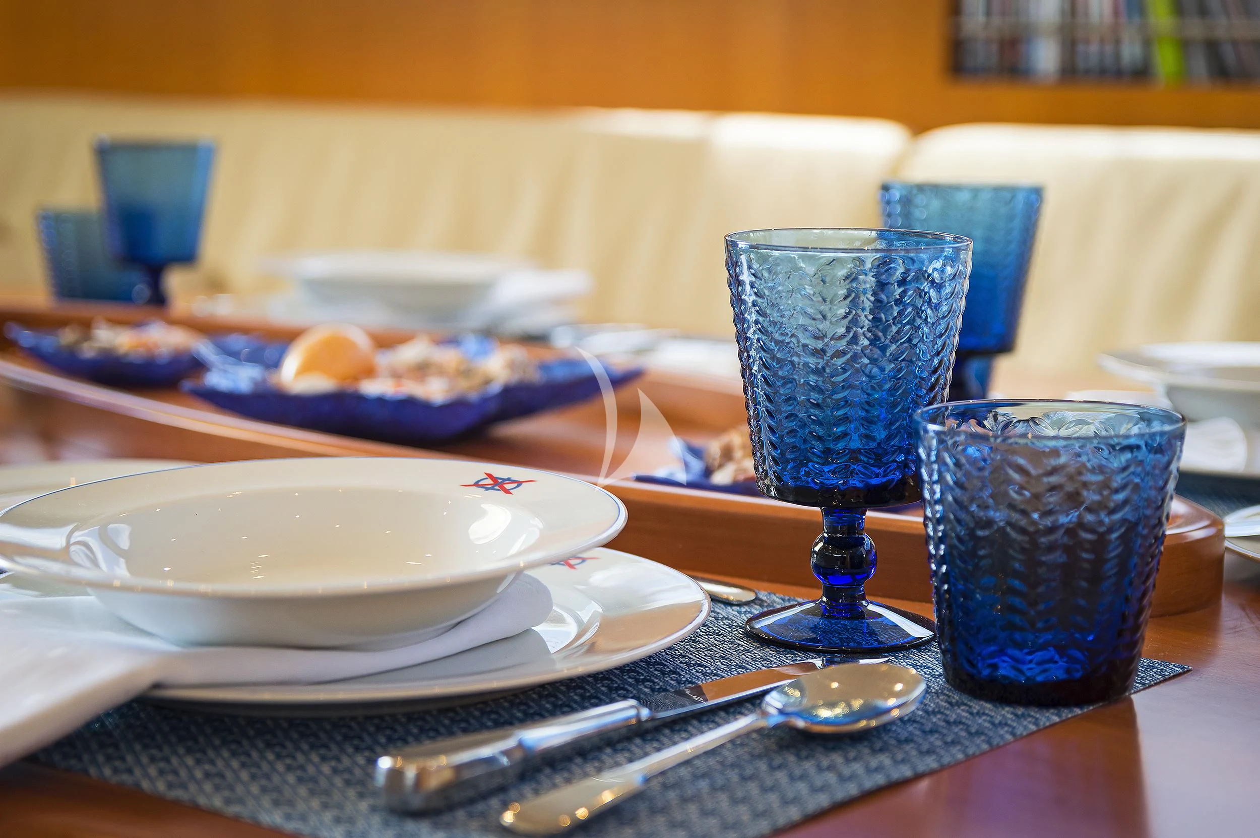 a table with plates and glasses on it aboard MELITI Yacht for Sale