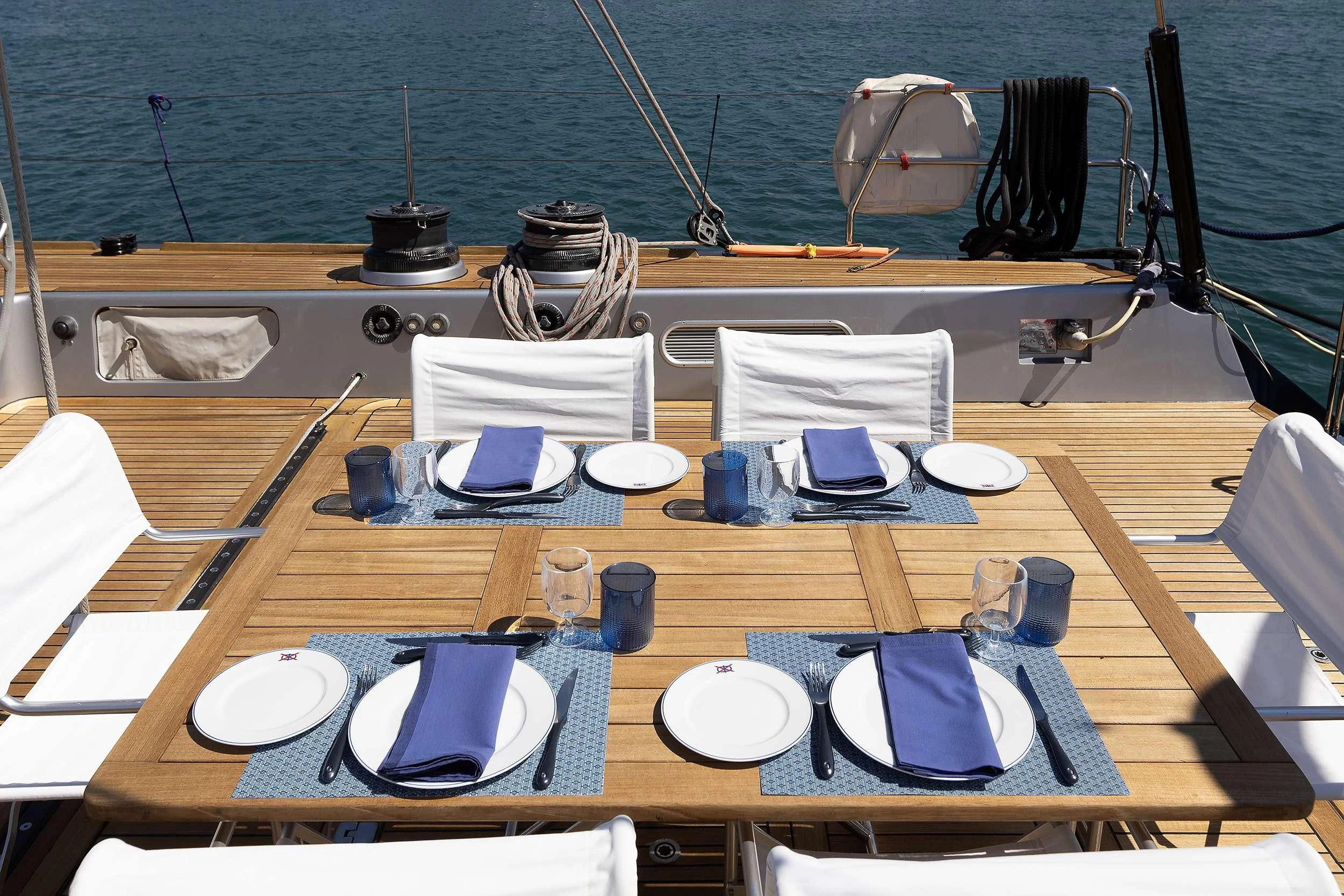 a table with plates and cups on it aboard MELITI Yacht for Sale