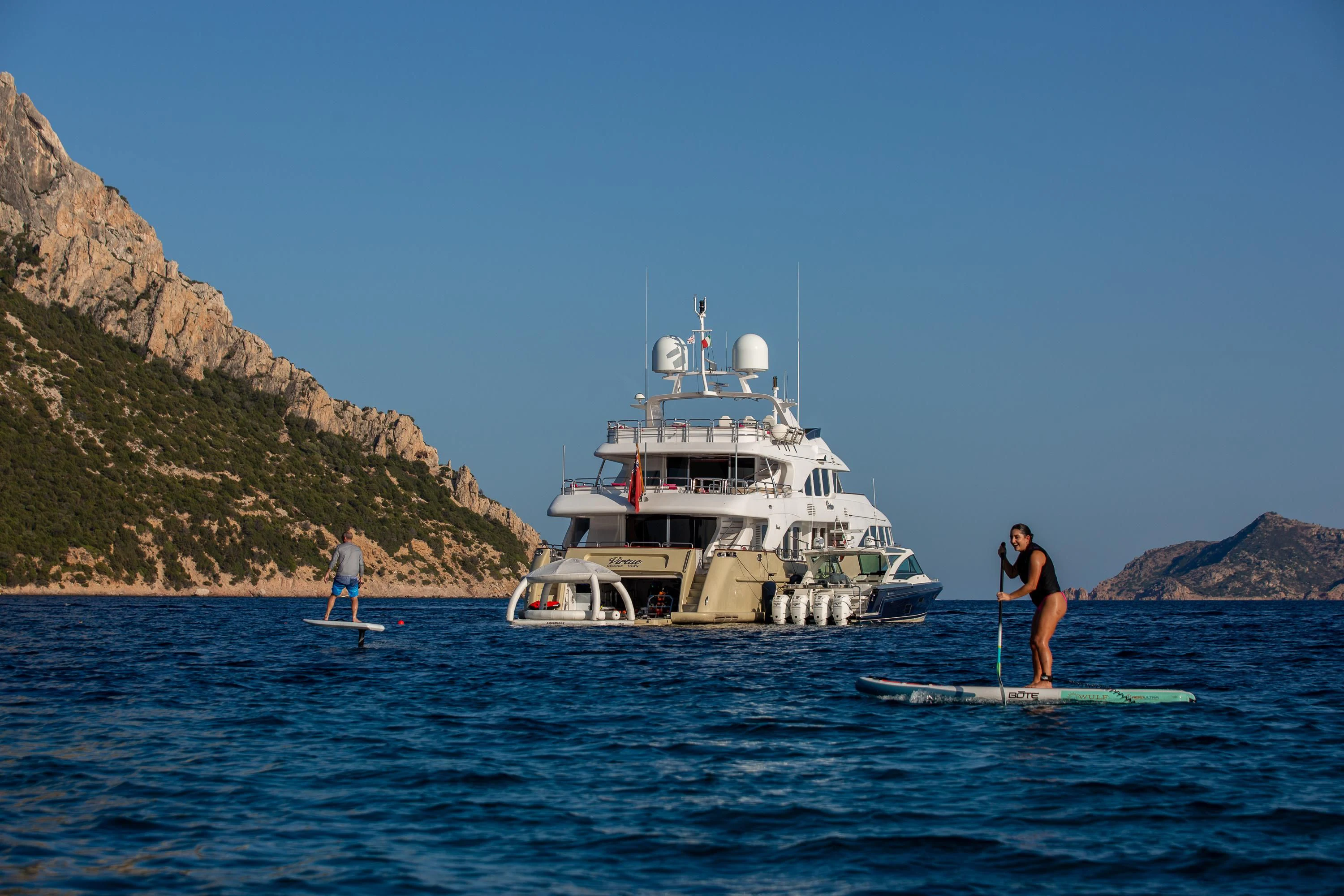 a couple of people stand on a boat in the water aboard VIRTUE Yacht for Sale