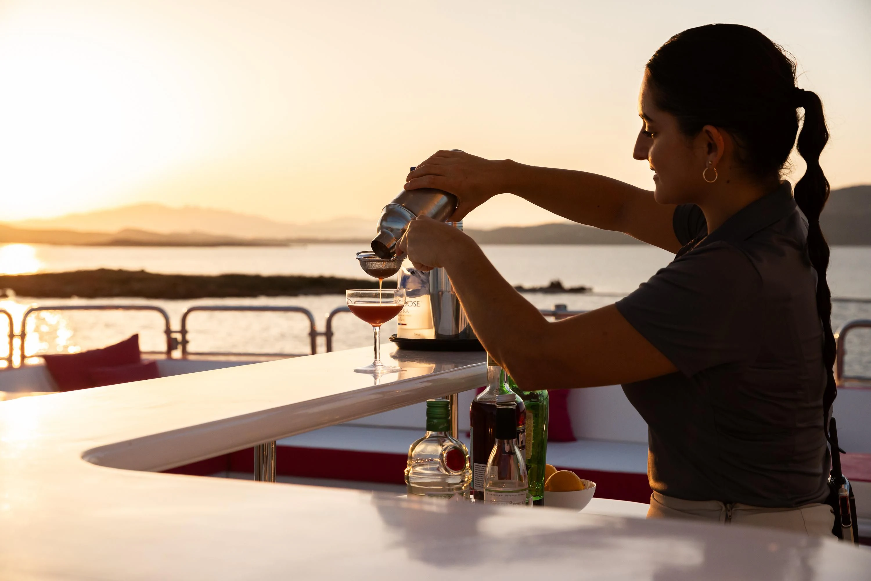 a person pouring a glass of wine aboard VIRTUE Yacht for Sale