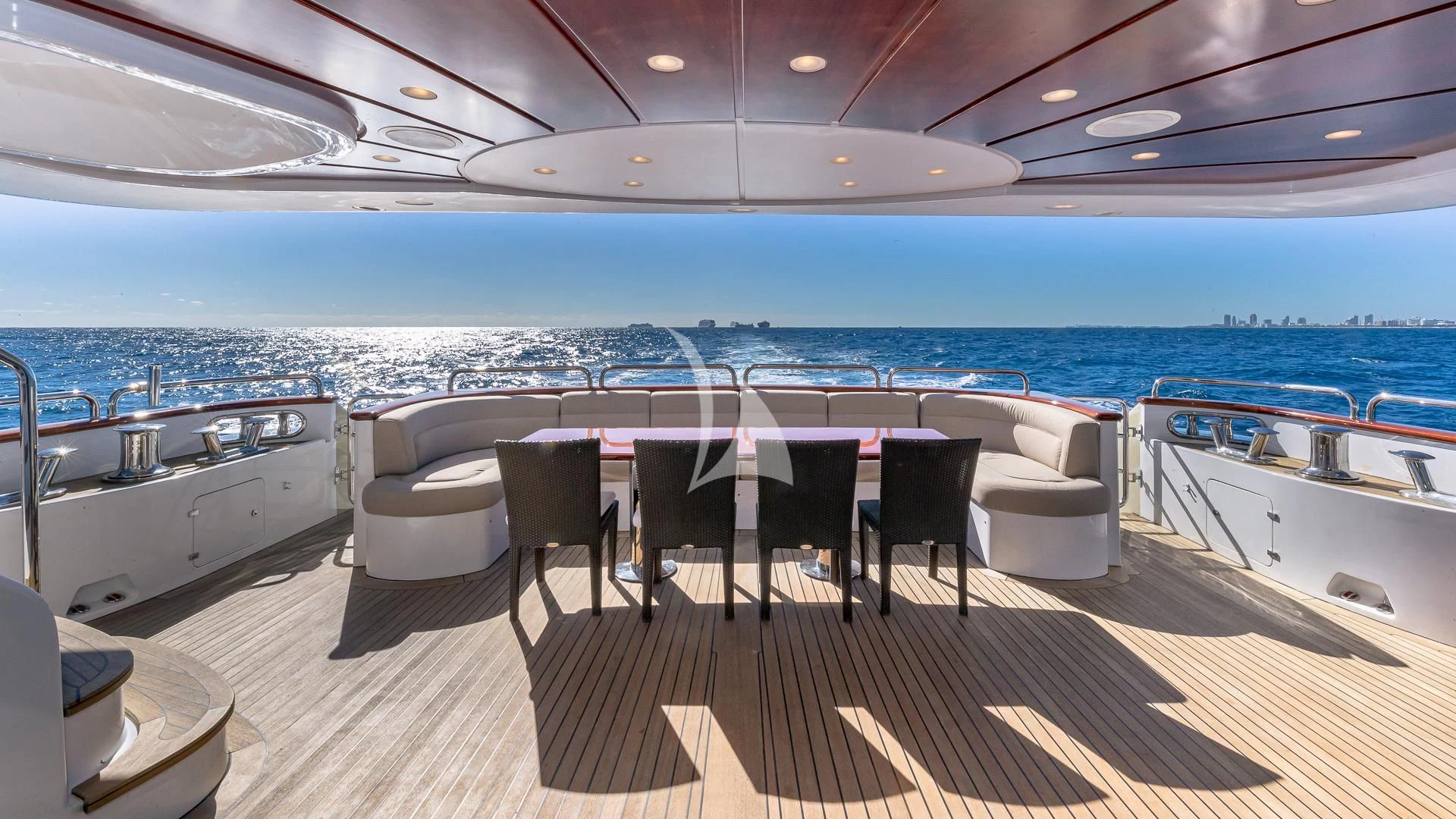 a table and chairs on a deck overlooking a large body of water aboard VIRTUE Yacht for Sale
