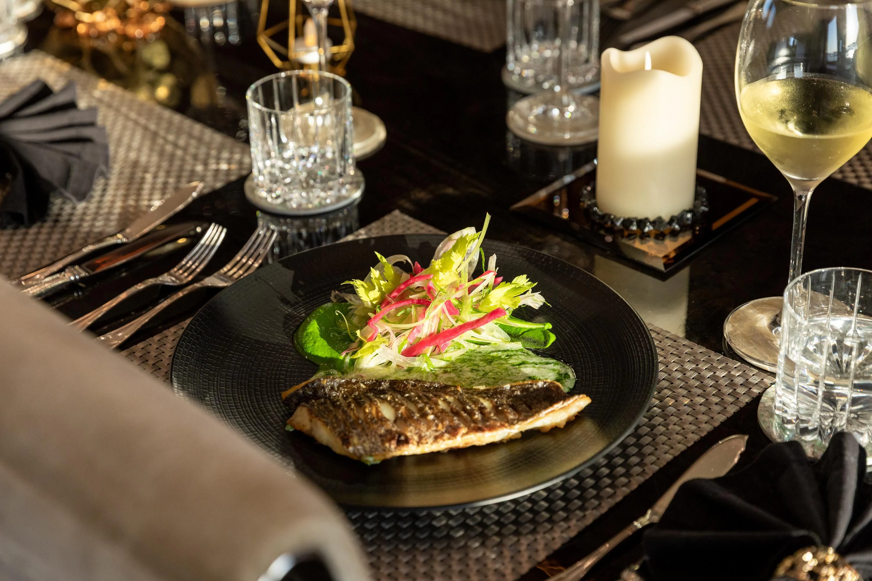 a plate of food and a glass of wine on a table aboard VIRTUE Yacht for Sale
