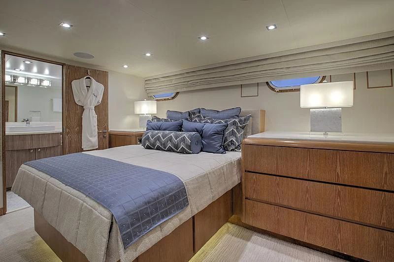 a bedroom with a bed and a dresser aboard WINNING HAND Yacht for Sale