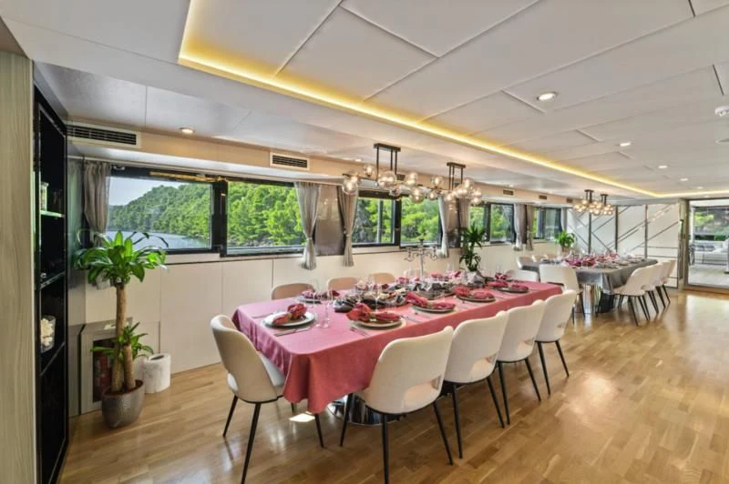 a room with tables and chairs aboard FREEDOM Yacht for Sale