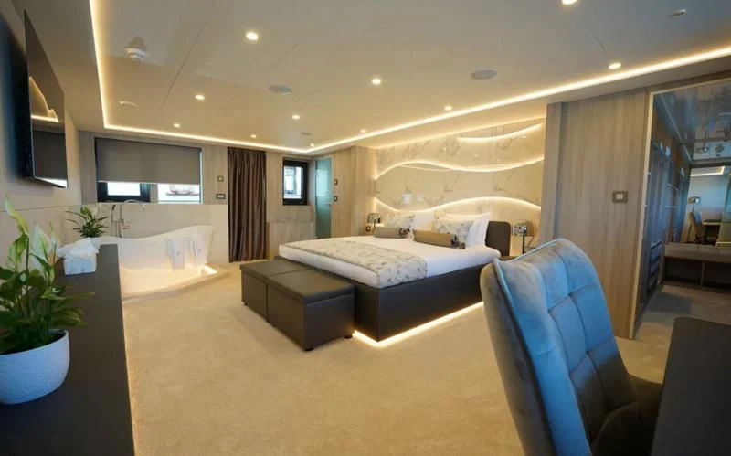 a room with a bed and a chair aboard FREEDOM Yacht for Sale