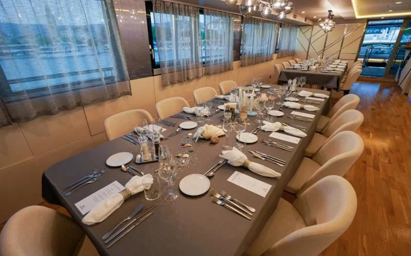 a table with plates and silverware aboard FREEDOM Yacht for Sale