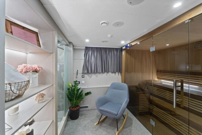 a room with a chair and a table and a plant in a pot aboard FREEDOM Yacht for Sale