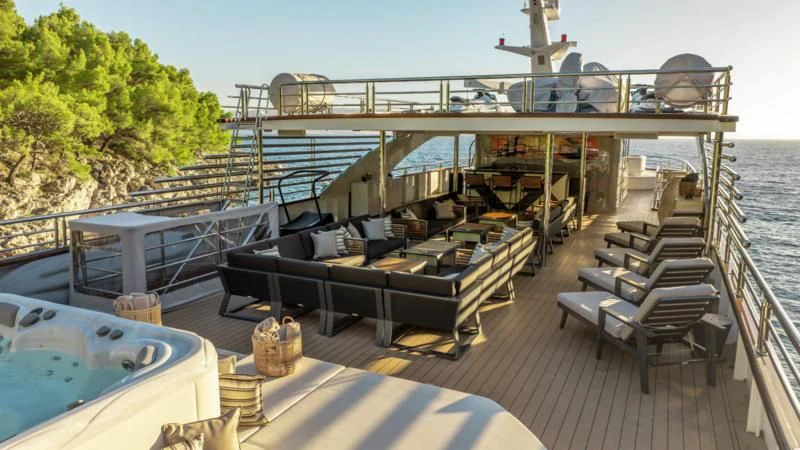 a deck with a deck and a large ship in the background aboard FREEDOM Yacht for Sale