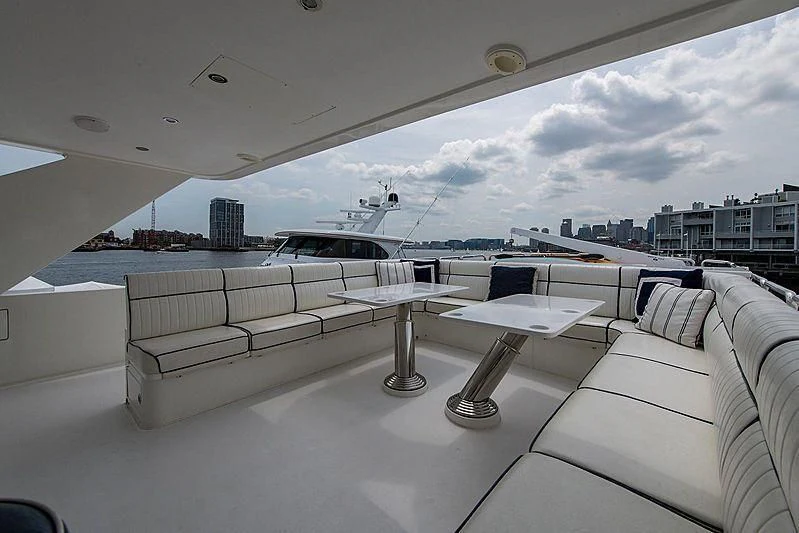 a white couch and a table with chairs on it aboard CIN-TAX Yacht for Sale