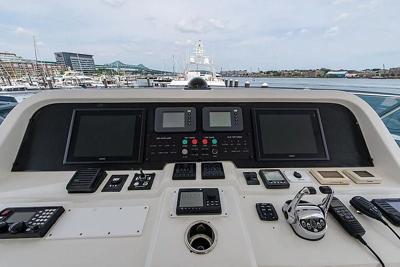 a black and silver console with a screen and buttons on a table with a ship in the background aboard CIN-TAX Yacht for Sale