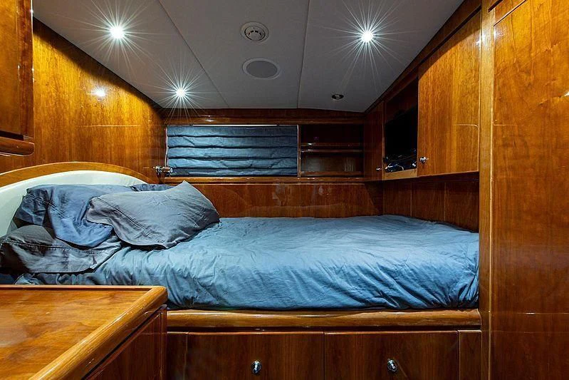 a bed with a blue comforter aboard CIN-TAX Yacht for Sale