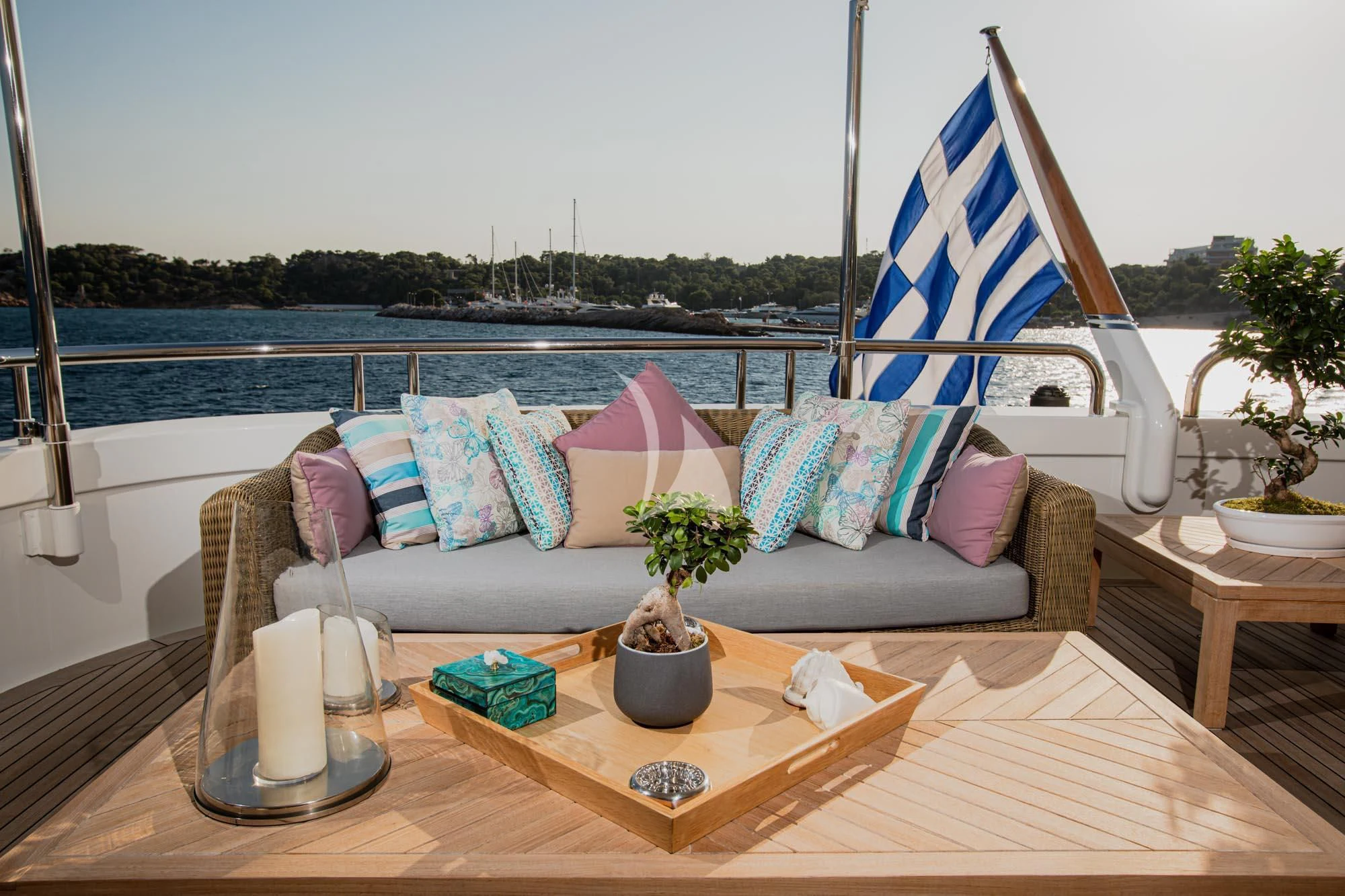 a couch with pillows and a table with a flag on it aboard MARLA Yacht for Sale