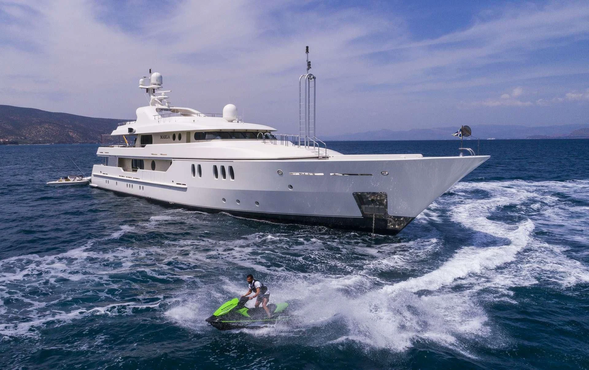 a person on a jet ski in the water next to a large white boat aboard MARLA Yacht for Sale