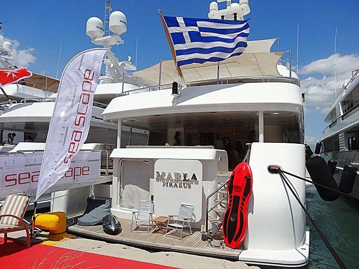 a large white boat with a flag on the front aboard MARLA Yacht for Sale