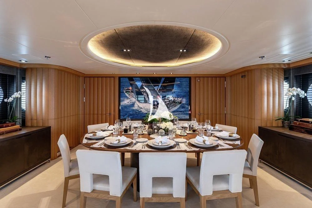 a large dining table with white chairs aboard DEJA TOO Yacht for Sale