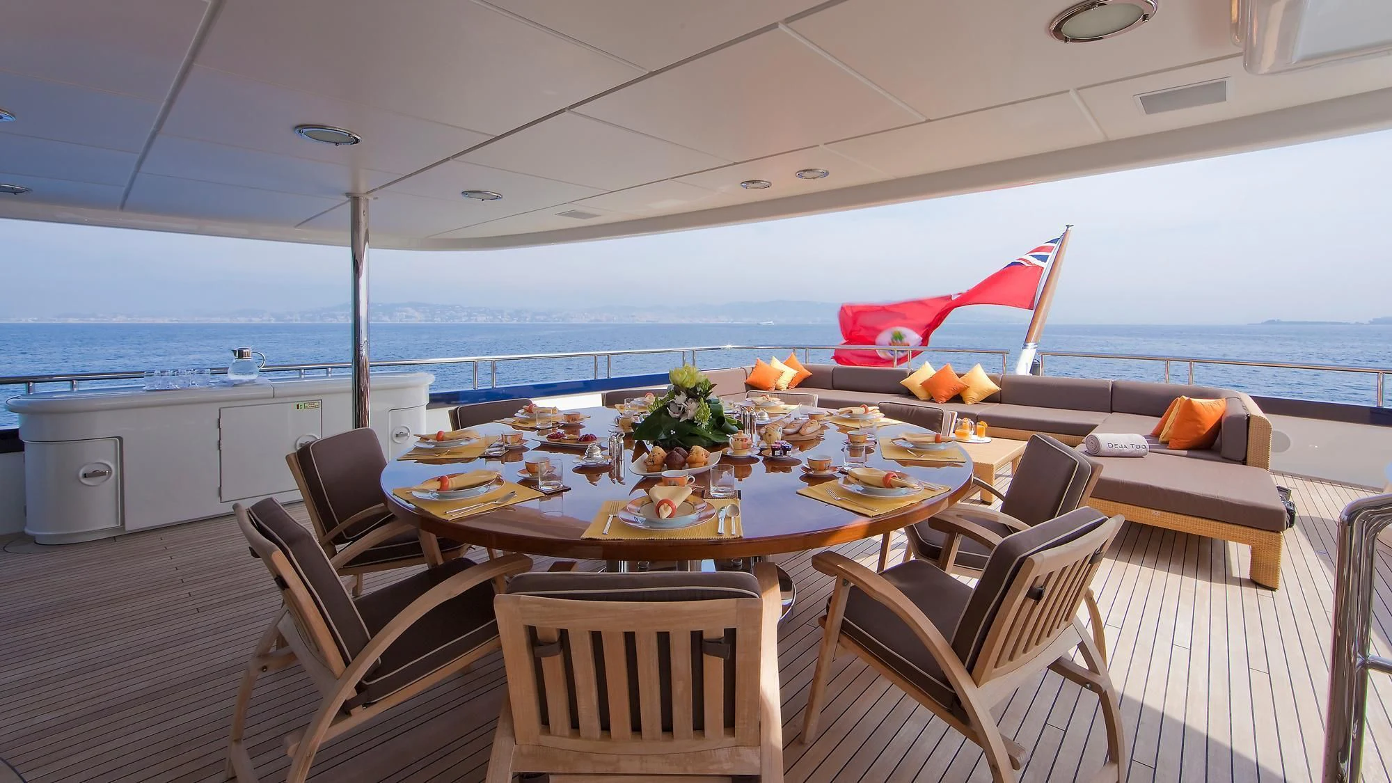a table with chairs and a view of the ocean aboard DEJA TOO Yacht for Sale