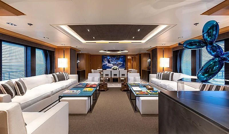 a room with a couch and a table with a large blue screen aboard DEJA TOO Yacht for Sale