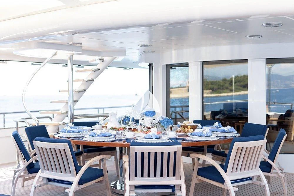 a room with tables and chairs aboard DEJA TOO Yacht for Sale
