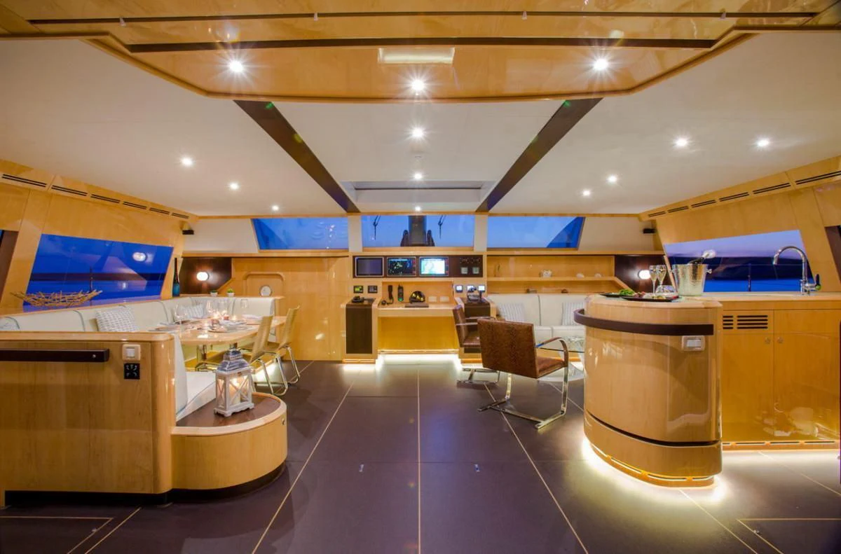 a large kitchen with a bar and seating area aboard WINDQUEST Yacht for Sale