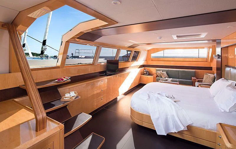 a room with a bed and a large window aboard WINDQUEST Yacht for Sale