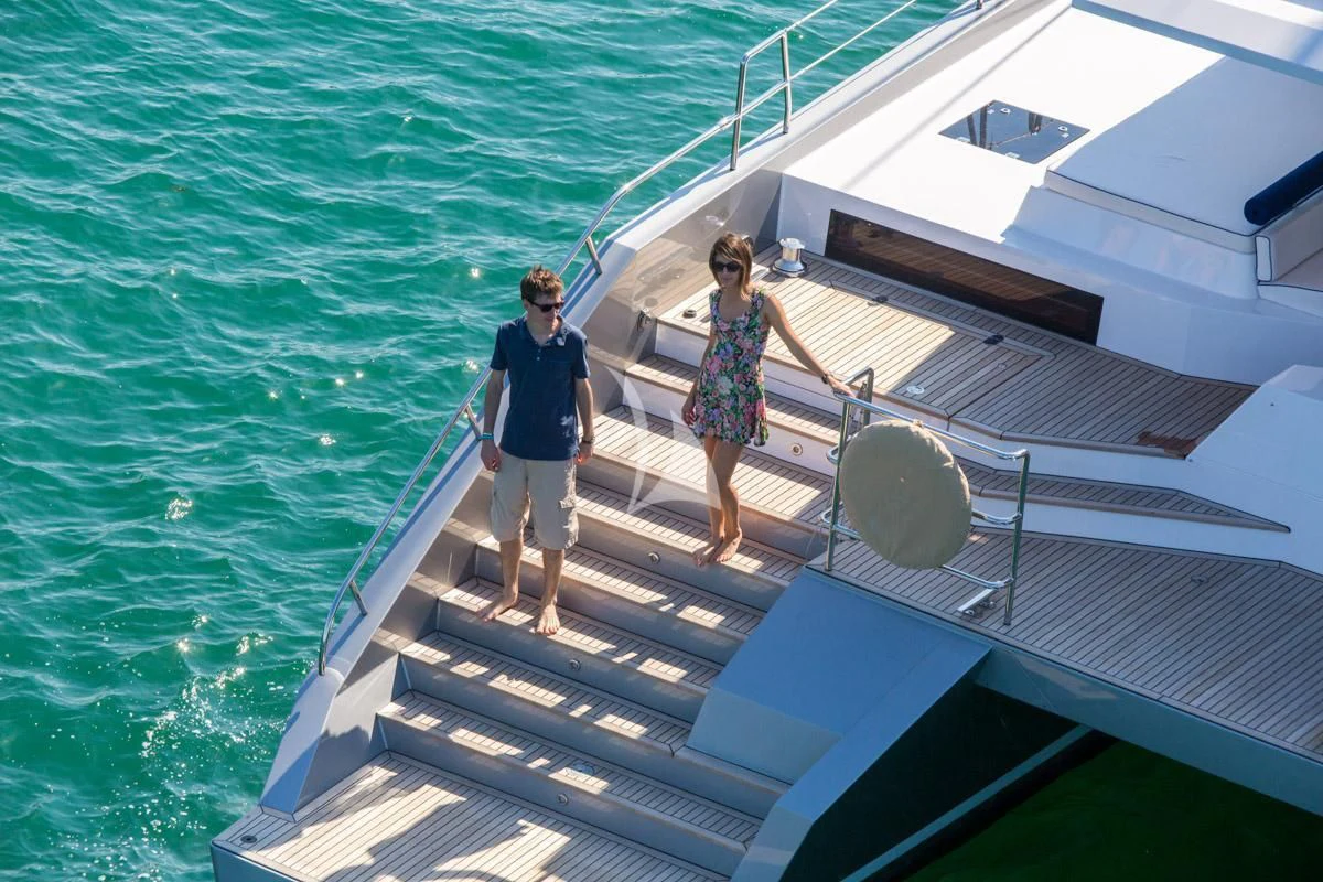 a man and woman walking on a boat aboard WINDQUEST Yacht for Sale