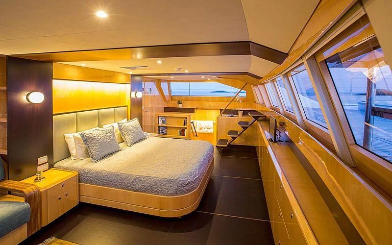 a bedroom with a bed and a window aboard WINDQUEST Yacht for Sale