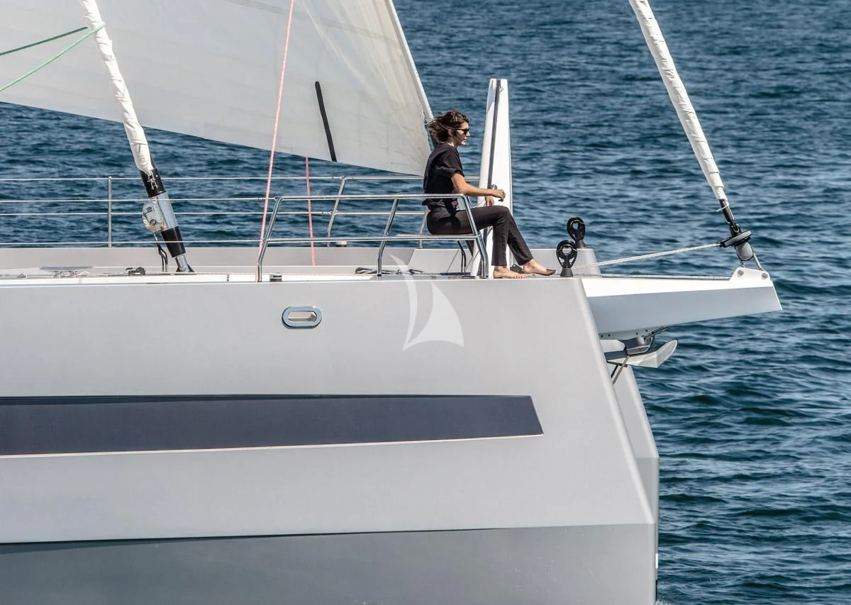 a couple of people sitting on a boat with a surfboard aboard WINDQUEST Yacht for Sale