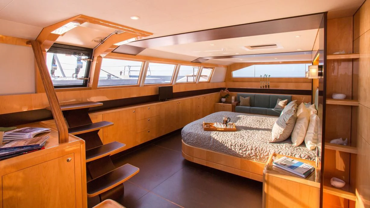 a bedroom with a bed and desk aboard WINDQUEST Yacht for Sale