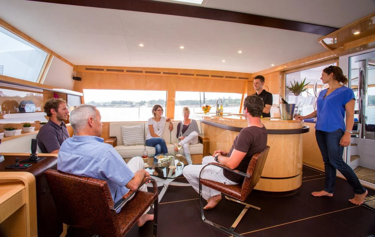 a group of people sitting around a table aboard WINDQUEST Yacht for Sale