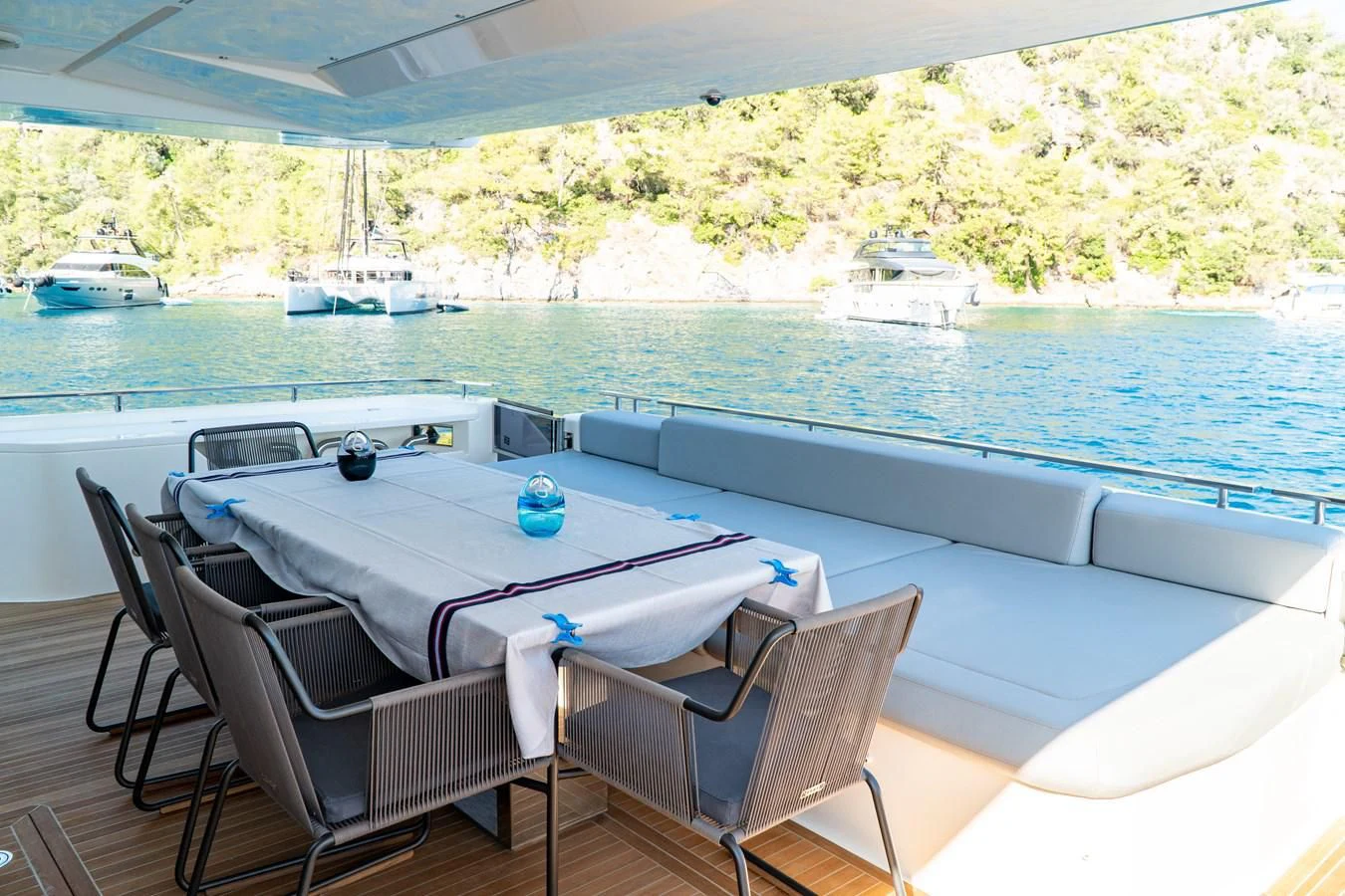 a table and chairs on a deck overlooking a body of water aboard LADY G Yacht for Sale