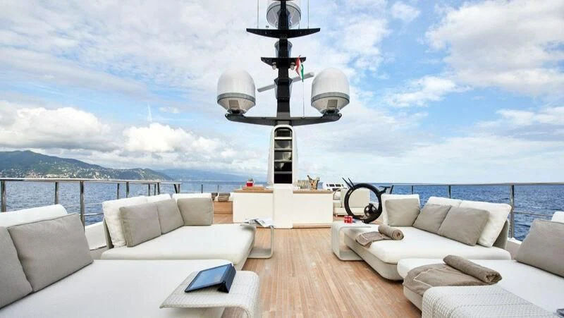 a room with a couch and a table and a lamp on the wall aboard NAYA 7 Yacht for Sale