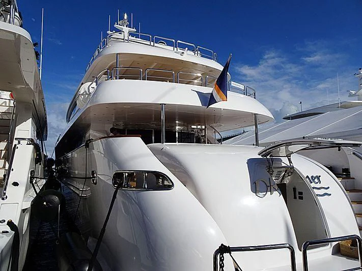 a large white boat with a flag on the front aboard TRUE NORTH Yacht for Sale