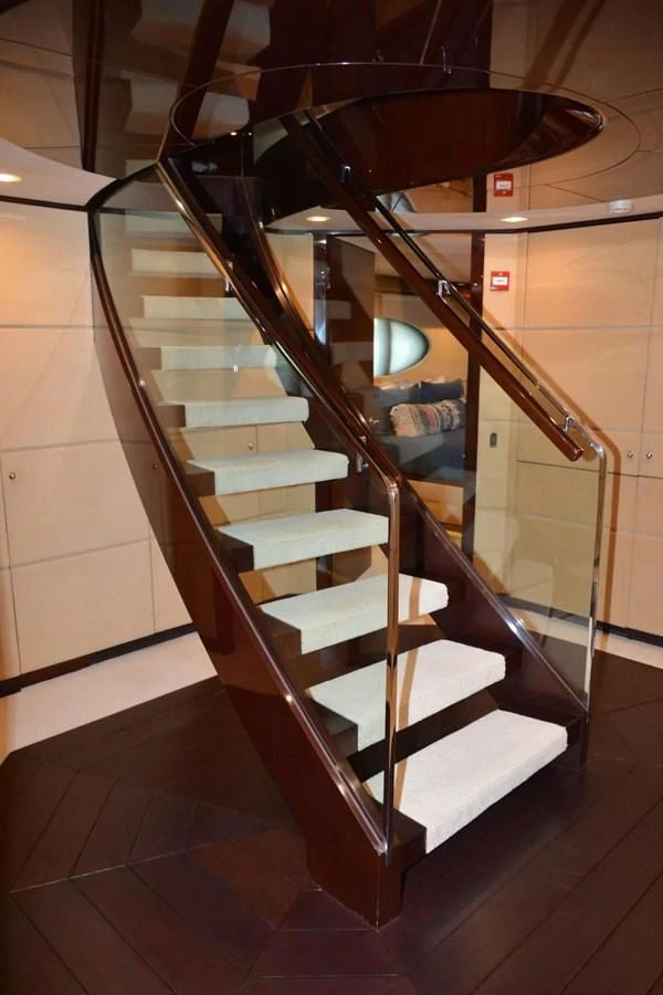 a staircase with a wood railing aboard TRUE NORTH Yacht for Sale