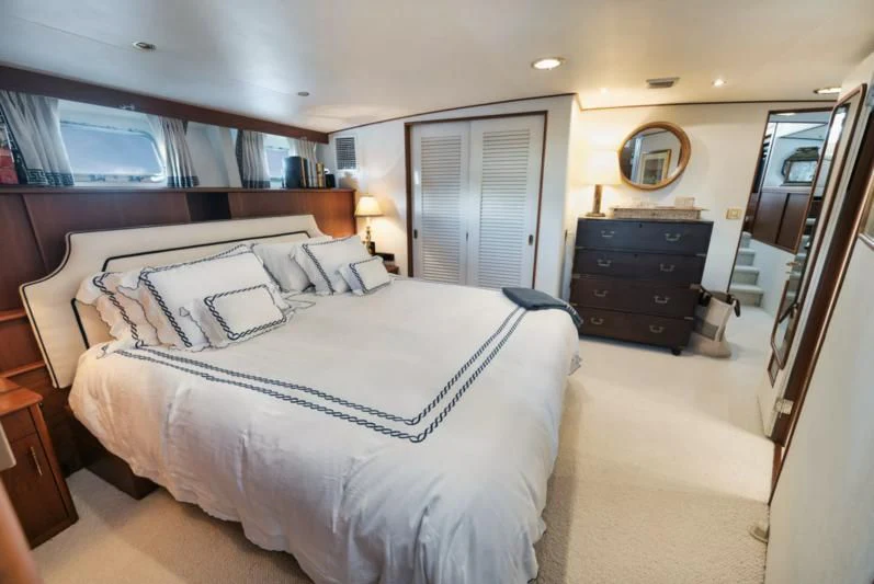 a bedroom with a bed and a dresser aboard SHARK Yacht for Sale