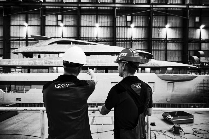 a couple of men holding a large knife in a warehouse aboard PROJECT FAITH Yacht for Sale